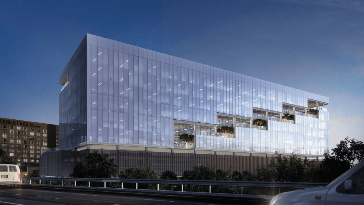 The Entrada office complex, a luminous white glazed volume above a slatted metal base